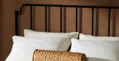 wrought iron headboard with decorative pillows